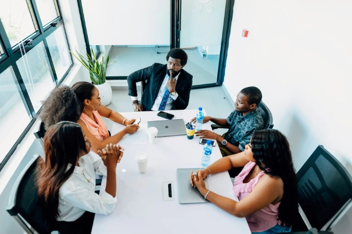 Un grupo de personas sentadas alrededor de una mesa blanca.